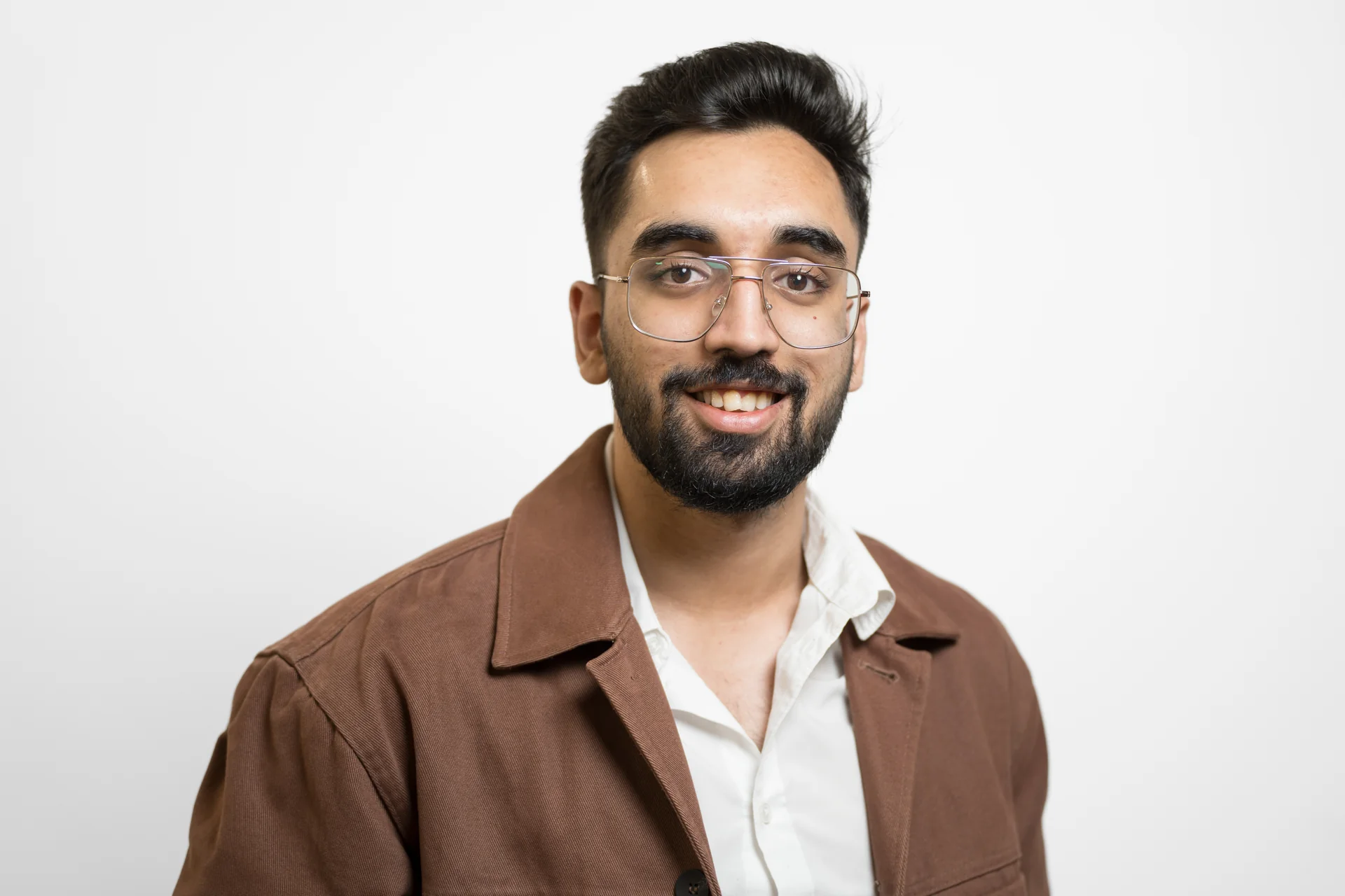 Keshav Jhawar smiling, wearing a brown jacket